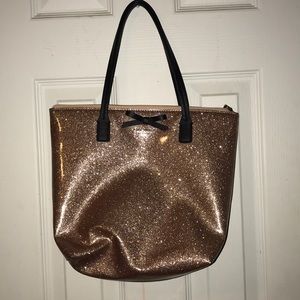 A sparkle rose gold Kate’s Spade purse.